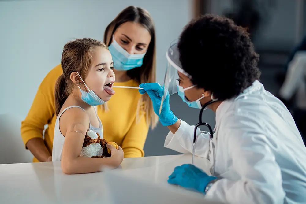 Child at a doctor getting her tonsils inspected.